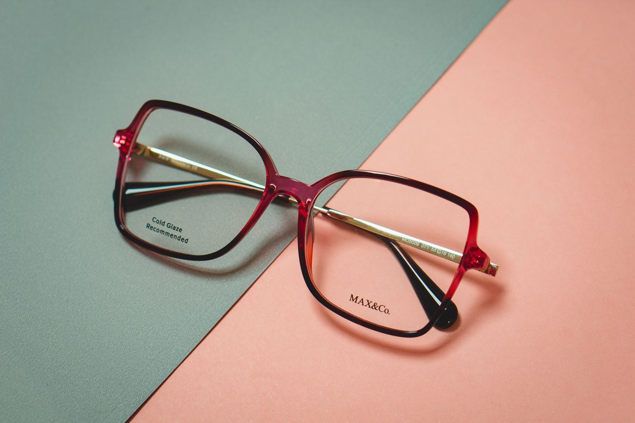 The Art of Drawing Readers In: Your attractive post title goes here Fashionable red square eyeglasses resting on a green and peach background. Modern eyewear style.